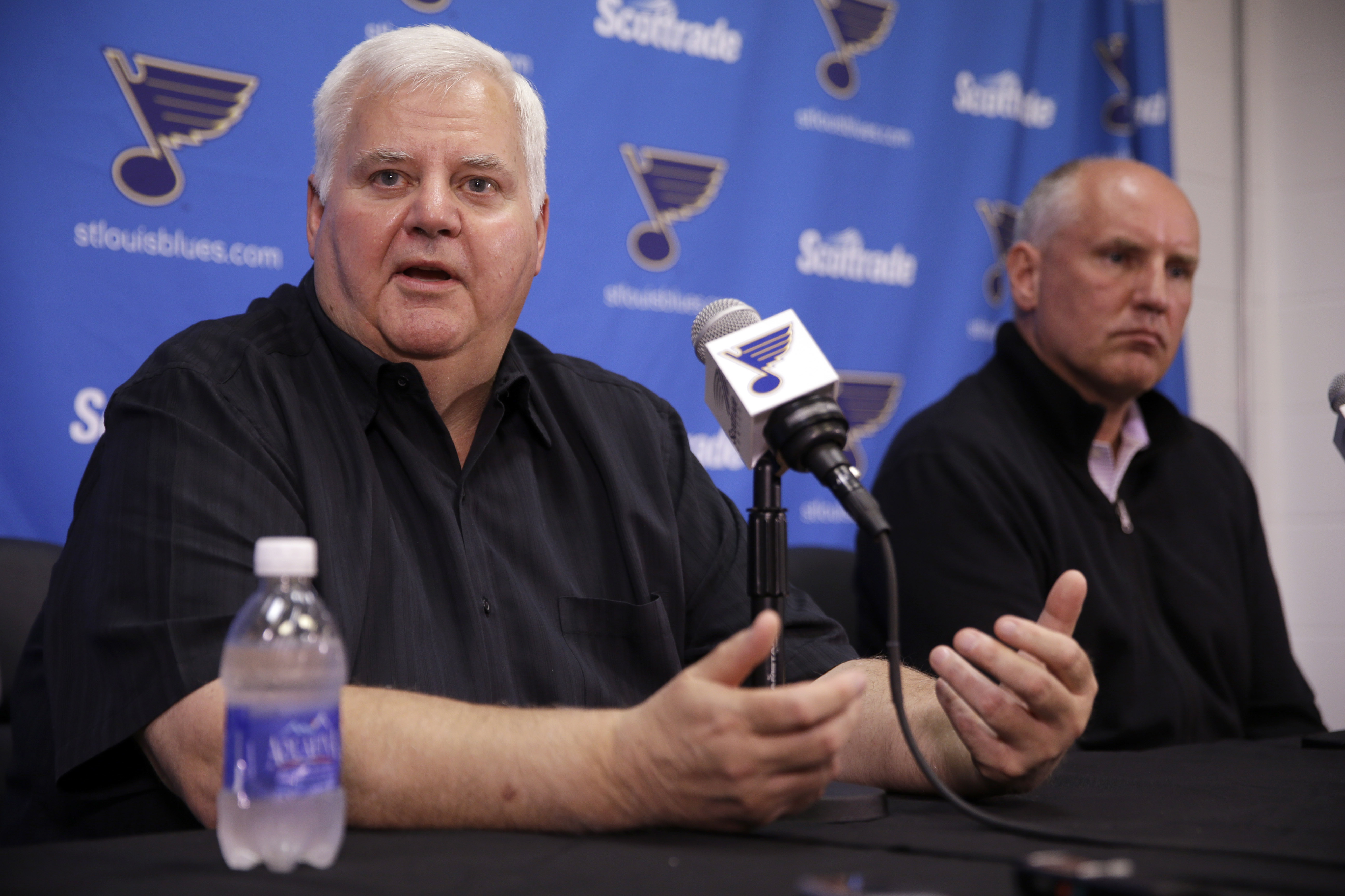 St. Louis Blues head coach Ken Hitchcock speaks along side general manager Doug Armstrong, right, during a news conference Tuesday, May 26, 2015, in St. Louis. The Blues are sticking with Hitchcock for another season, announcing the veteran NHL hockey coach has signed a one-year contract with the team. (AP Photo/Jeff Roberson)