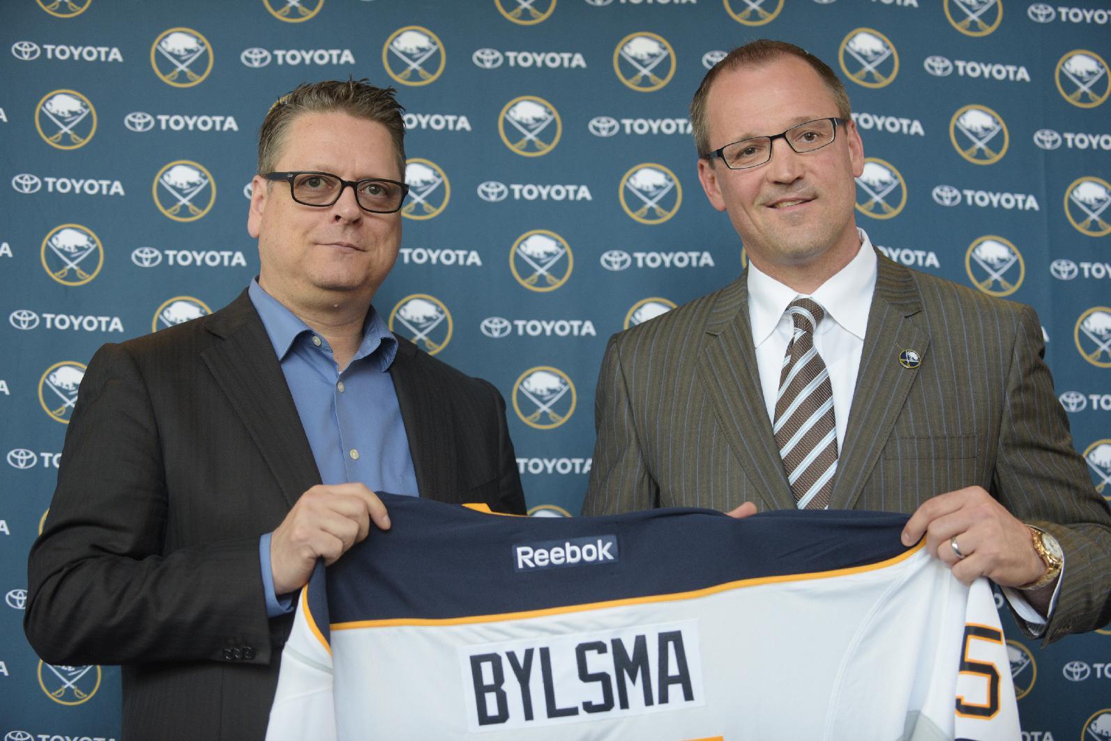 Buffalo Sabres GM Tim Murray, left, and newly hired coach Dan Bylsma hold a Sabres' jersey as they pose for a photo after a news conference Thursday, May 28, 2015, in Buffalo, N.Y. A week after losing out on Mike Babcock, the Buffalo Sabres went with another experienced Stanley Cup winner by hiring Dan Bylsma to become their next coach. (AP Photo/Gary Wiepert)