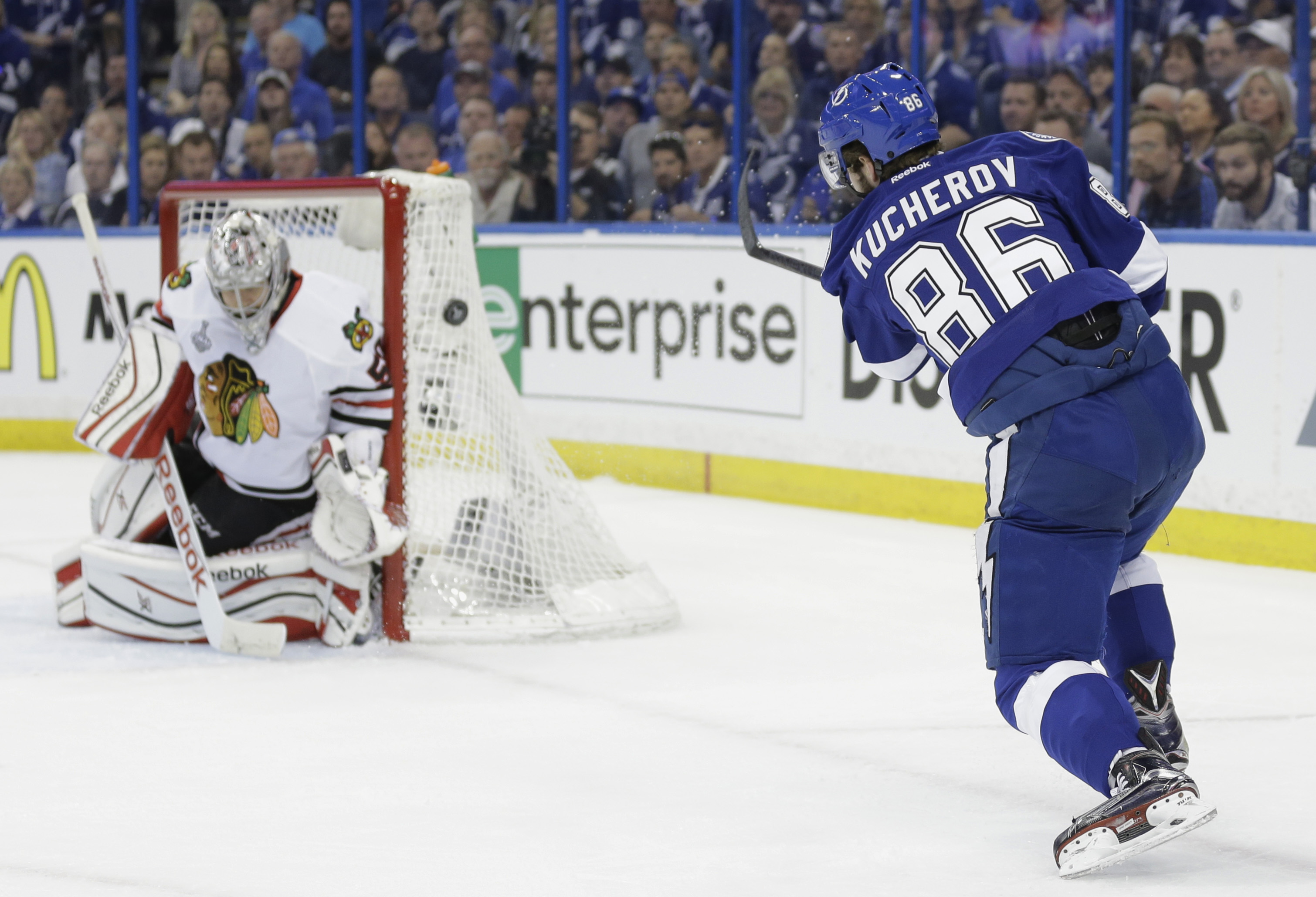 Chicago Blackhawks goalie Corey Crawford (50), left, blocks a shot by Tampa Bay Lightning right wing Nikita Kucherov (86), during the first period in Game 1 of the NHL hockey Stanley Cup Final in Tampa, Fla., Wednesday, June 3, 2015. (AP Photo/Chris O'Meara)