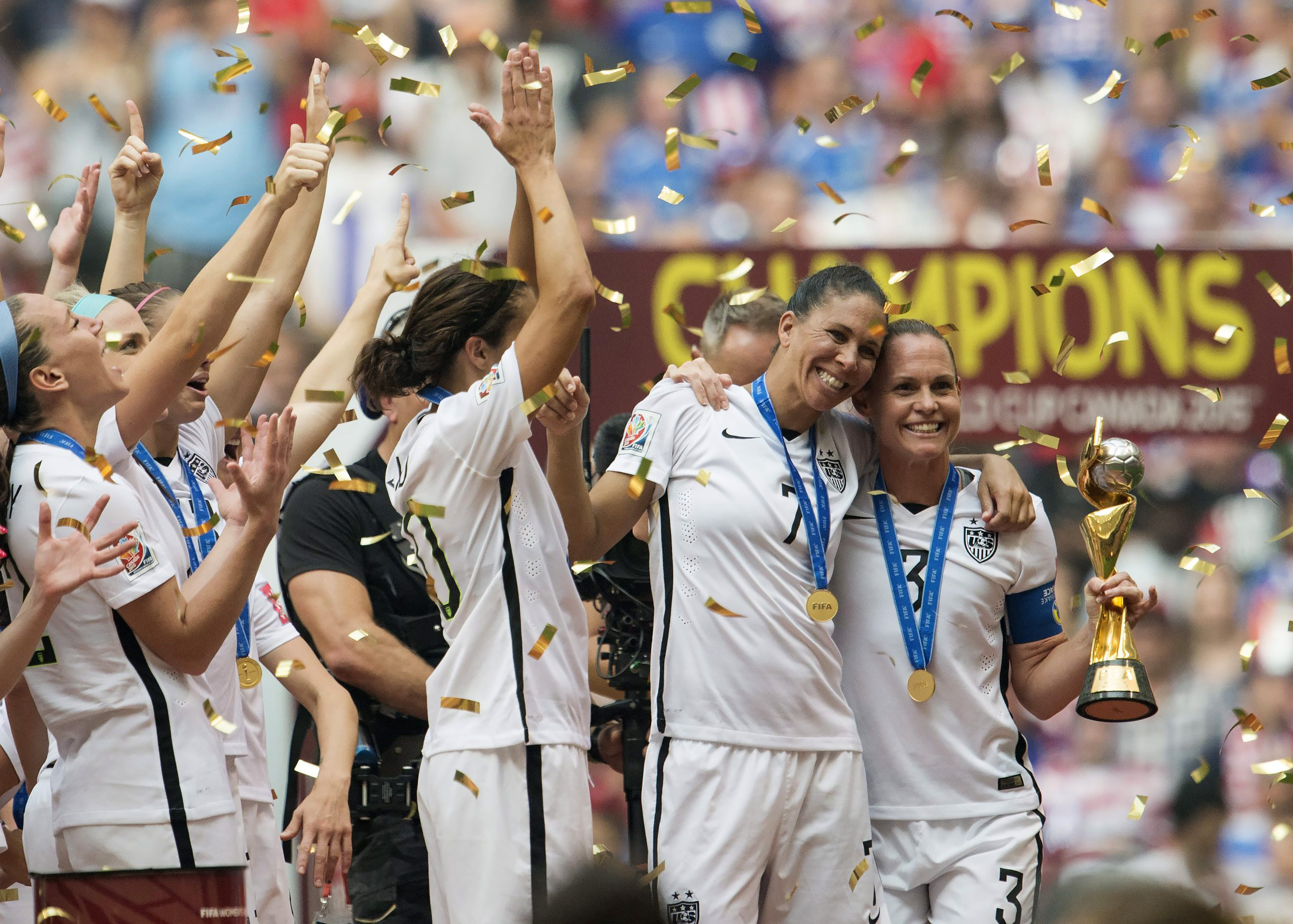 USA teammates Shannon Boxx, second from right, and Christie Rampone, far right, pose with the trophy as the USA team celebrates following their win over Japan at the f FIFA Women's World Cup soccer championship in Vancouver, British Columbia, Canada, Sunday, July 5, 2015. (Jonathan Hayward/The Canadian Press via AP) MANDATORY CREDIT