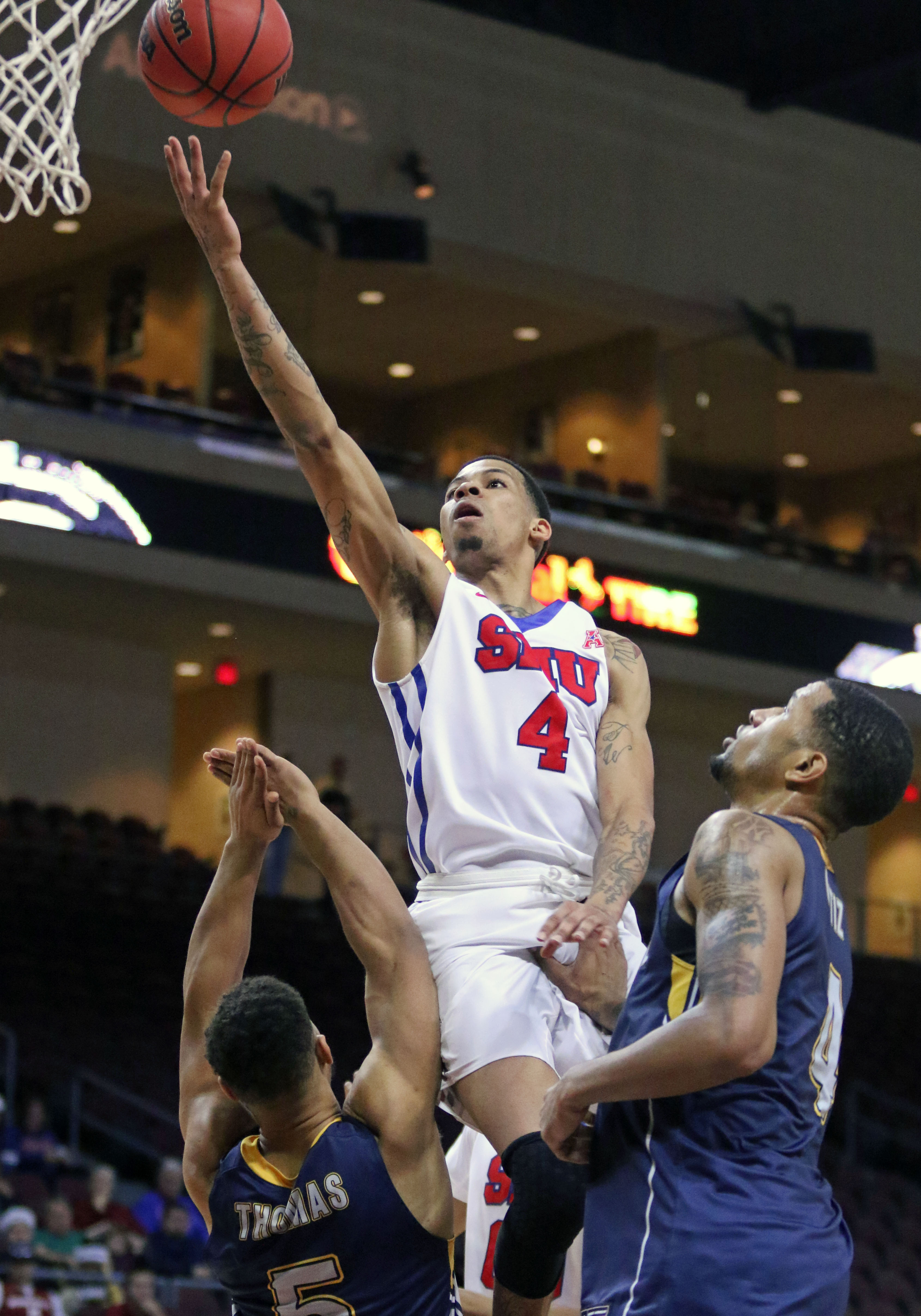 CORRECTS DAY OF WEEK TO TUESDAY FROM WEDNESDAY - SMU's Keith Frazier drives by Kent State's Kellon Thomas, left, in the second half of an NCAA college basketball game Tuesday, Dec. 22, 2015, in Las Vegas. Kent State's Chris Ortiz stands nearby. SMU won 90-74. (AP Photo/Ronda Churchill)