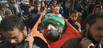 Palestinian mourners carry the body of Hamas militant Ahmad El Shaer, who was killed in an Israeli missile strike, during his funeral in the Rafah refugee camp, southern Gaza Strip, Sunday, Jan. 11, 2009. Israeli troops battled Palestinian gunmen in a suburb of Gaza City on Sunday morning as Israel's military inched closer to Gaza's main population centers despite growing diplomatic pressure to end the conflict. (AP Photo/Eyad Baba)