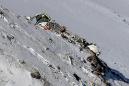 Iran teams carry plane crash dead down from mountain