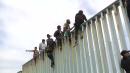 Migrants scale U.S.-Mexico border wall during protest